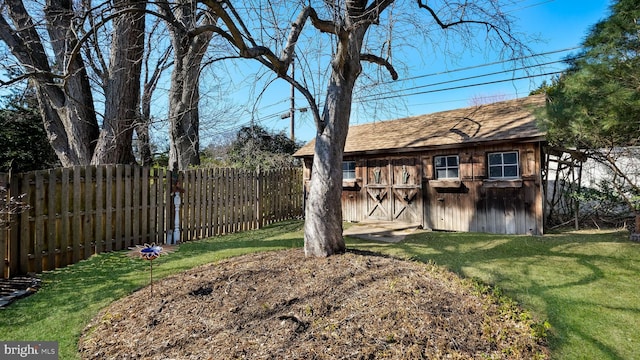 view of yard featuring an outdoor structure, a fenced backyard, and a shed