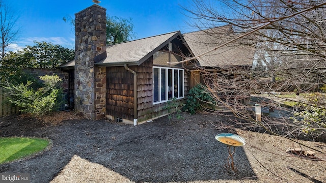 view of side of property with roof with shingles