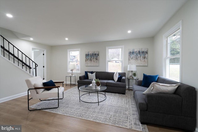 living area featuring recessed lighting, stairway, plenty of natural light, and wood finished floors