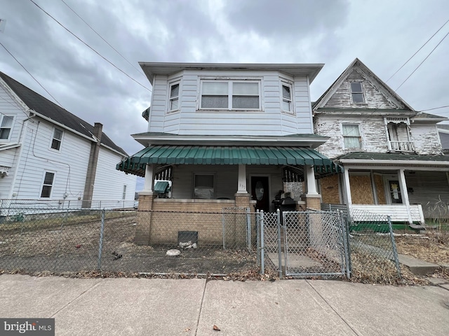 view of front facade featuring a fenced front yard, a porch, and a gate