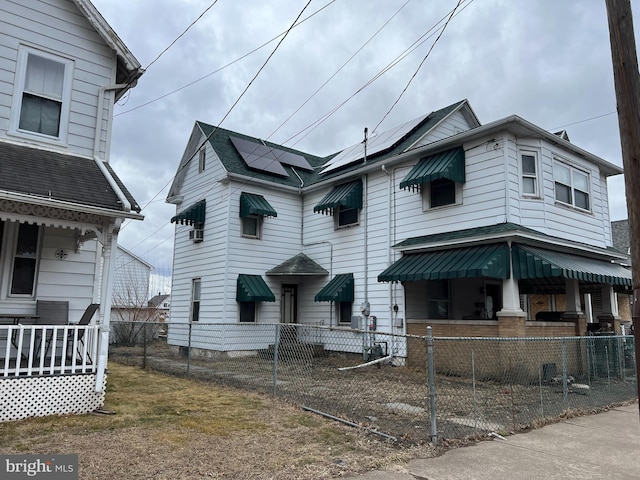 view of front of home featuring covered porch and a fenced front yard