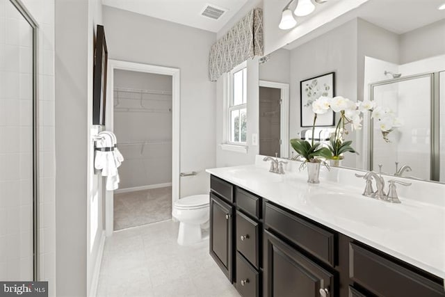 full bathroom featuring a spacious closet, visible vents, a shower stall, and a sink