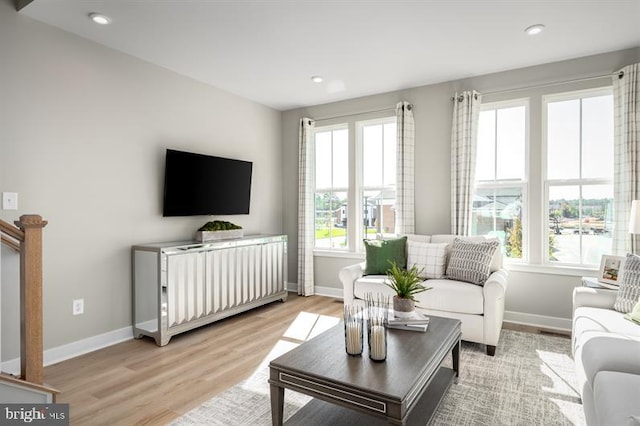 living area featuring a healthy amount of sunlight, light wood-type flooring, and baseboards