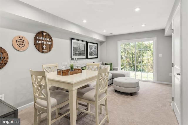 dining room with recessed lighting, light colored carpet, and baseboards