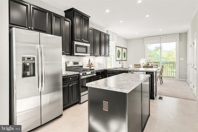 kitchen with dark cabinetry, light countertops, tasteful backsplash, and stainless steel appliances