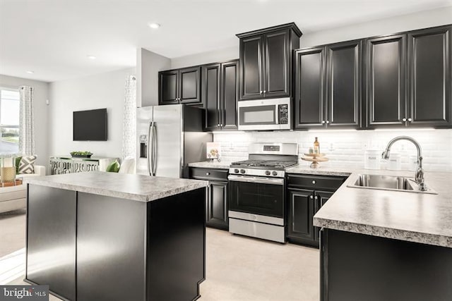 kitchen featuring tasteful backsplash, dark cabinets, appliances with stainless steel finishes, and a sink