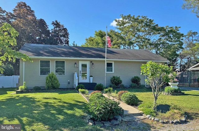 ranch-style house with a front yard and fence