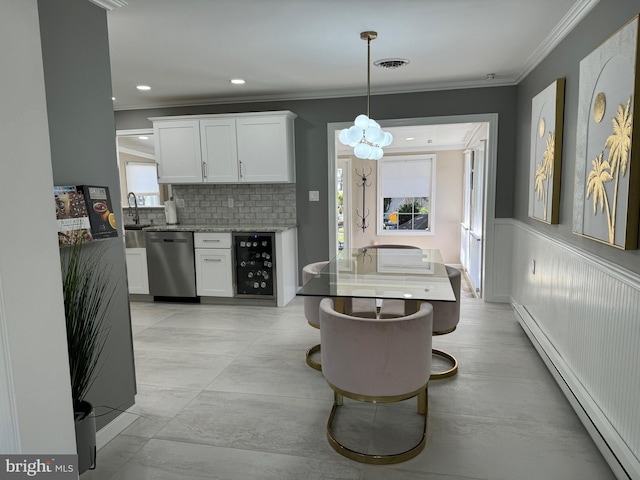 dining area featuring a wainscoted wall, wine cooler, an inviting chandelier, crown molding, and a baseboard radiator