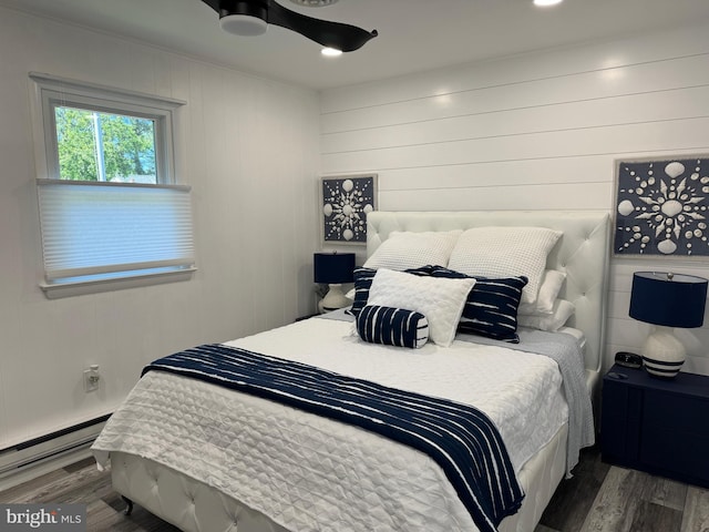 bedroom with recessed lighting, wood finished floors, and a baseboard radiator