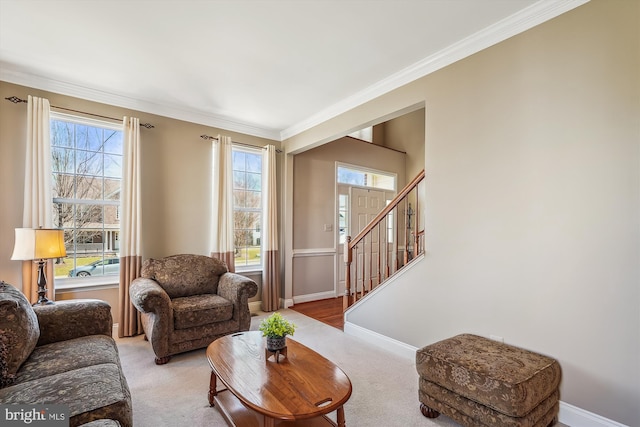 living area featuring plenty of natural light, light colored carpet, crown molding, and baseboards