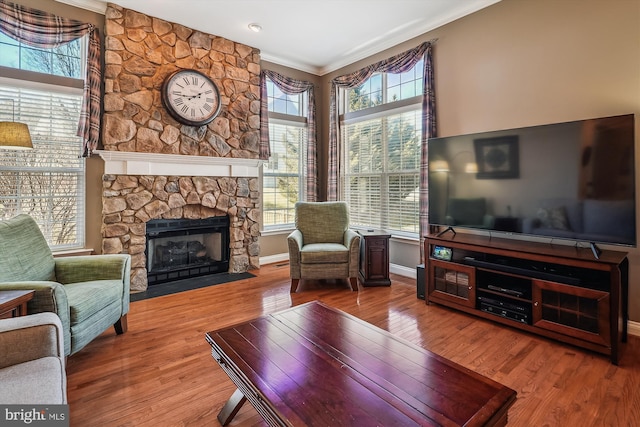 living area with plenty of natural light, wood finished floors, and crown molding