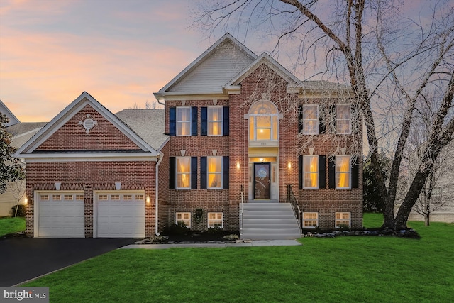 view of front facade with brick siding, driveway, and a front yard