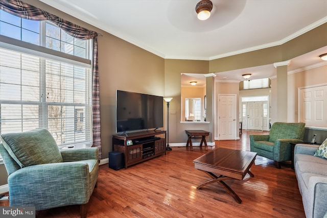 living room featuring ceiling fan, baseboards, wood finished floors, and ornamental molding