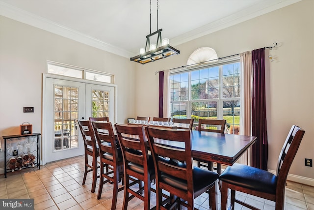 dining area with light tile patterned flooring, plenty of natural light, french doors, and ornamental molding