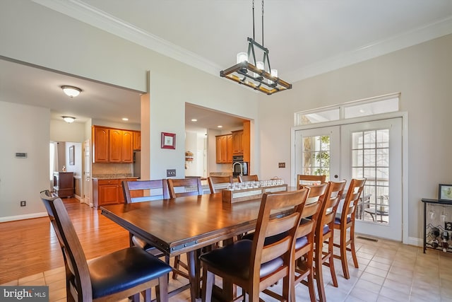 dining area with crown molding, light tile patterned flooring, and baseboards