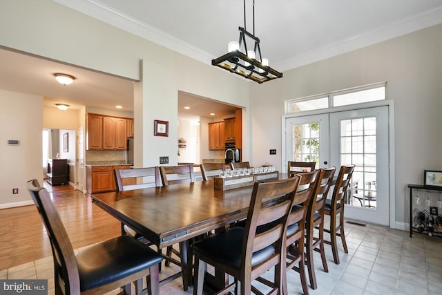 dining space with crown molding, light tile patterned floors, french doors, and baseboards