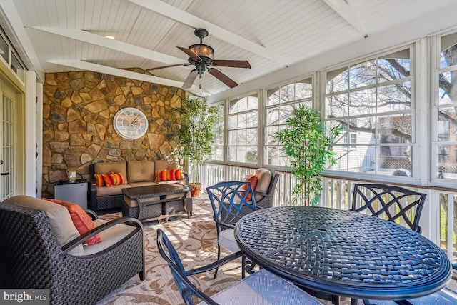 sunroom / solarium with vaulted ceiling with beams and a ceiling fan