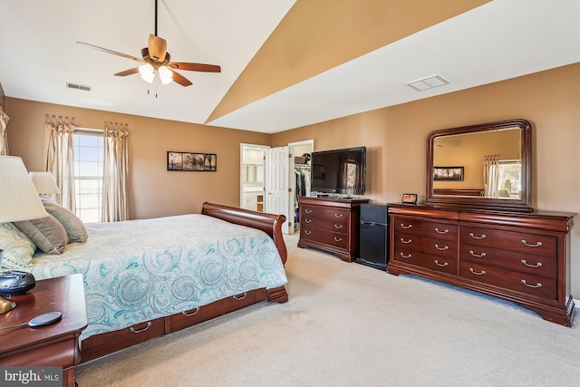 bedroom featuring visible vents, lofted ceiling, a spacious closet, a closet, and light carpet