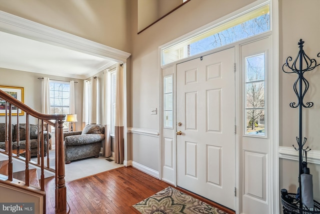 foyer entrance with stairs, hardwood / wood-style flooring, and baseboards