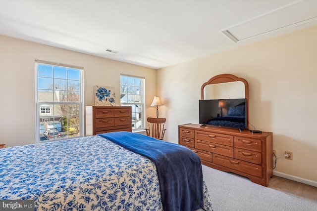 bedroom featuring visible vents, attic access, baseboards, and carpet floors