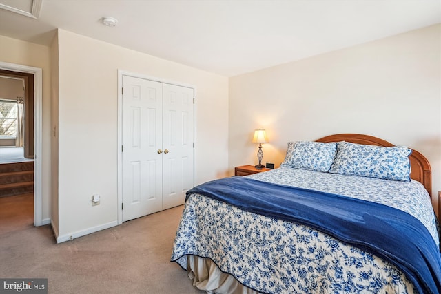 carpeted bedroom featuring a closet and baseboards