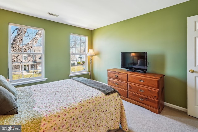 carpeted bedroom with visible vents and baseboards