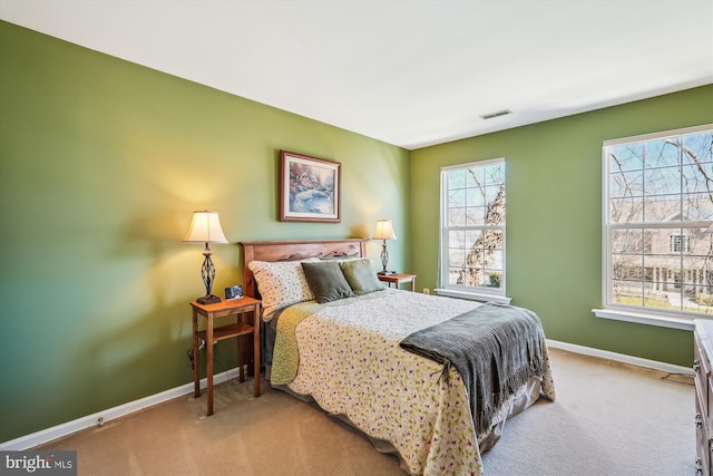 bedroom with visible vents, carpet floors, and multiple windows