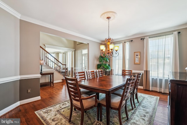 dining area with stairway, wood-type flooring, an inviting chandelier, and crown molding