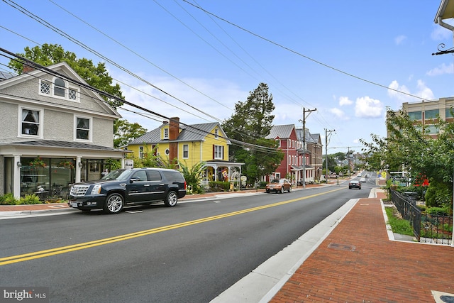 view of road featuring sidewalks, curbs, and street lighting