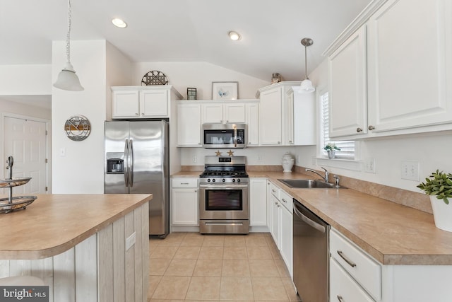 kitchen featuring a sink, appliances with stainless steel finishes, white cabinets, light tile patterned floors, and lofted ceiling