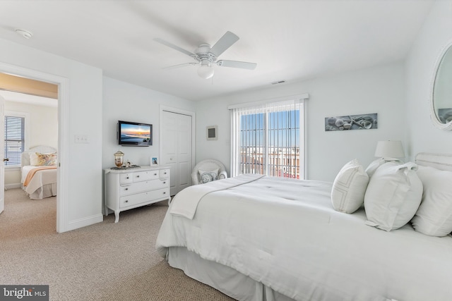 bedroom featuring visible vents, ceiling fan, baseboards, light carpet, and a closet