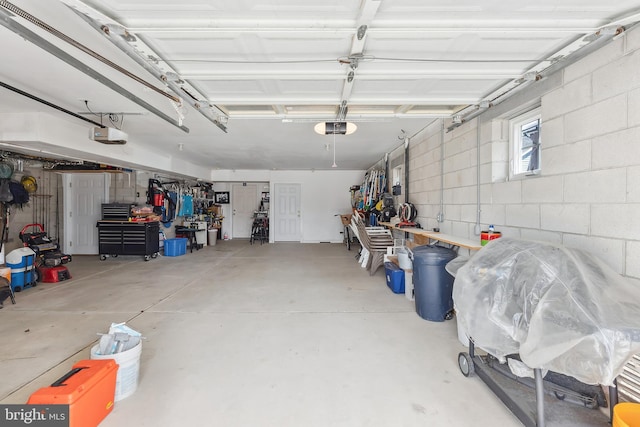 garage featuring a garage door opener and concrete block wall