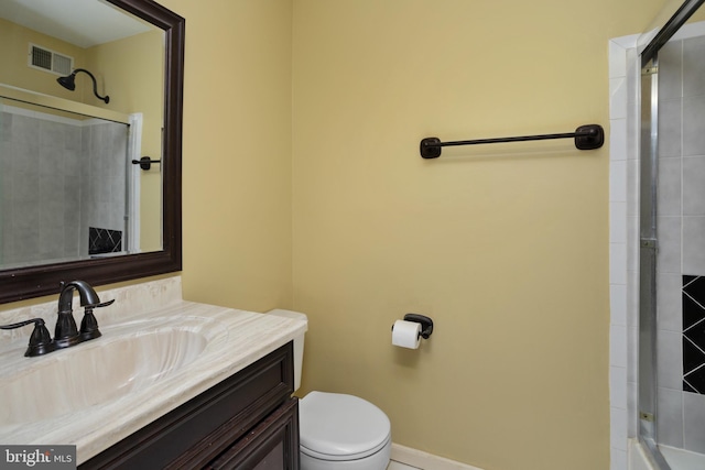 bathroom featuring a shower with door, visible vents, toilet, and vanity