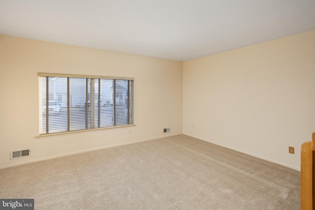 empty room with visible vents, baseboards, and carpet