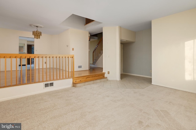 spare room with stairs, visible vents, baseboards, and carpet flooring