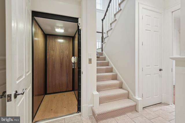 entryway featuring stairs, elevator, and baseboards