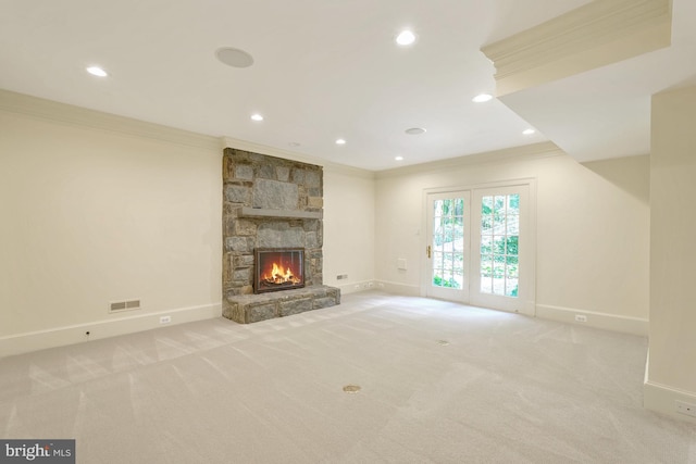 unfurnished living room featuring carpet flooring, a fireplace, baseboards, and ornamental molding