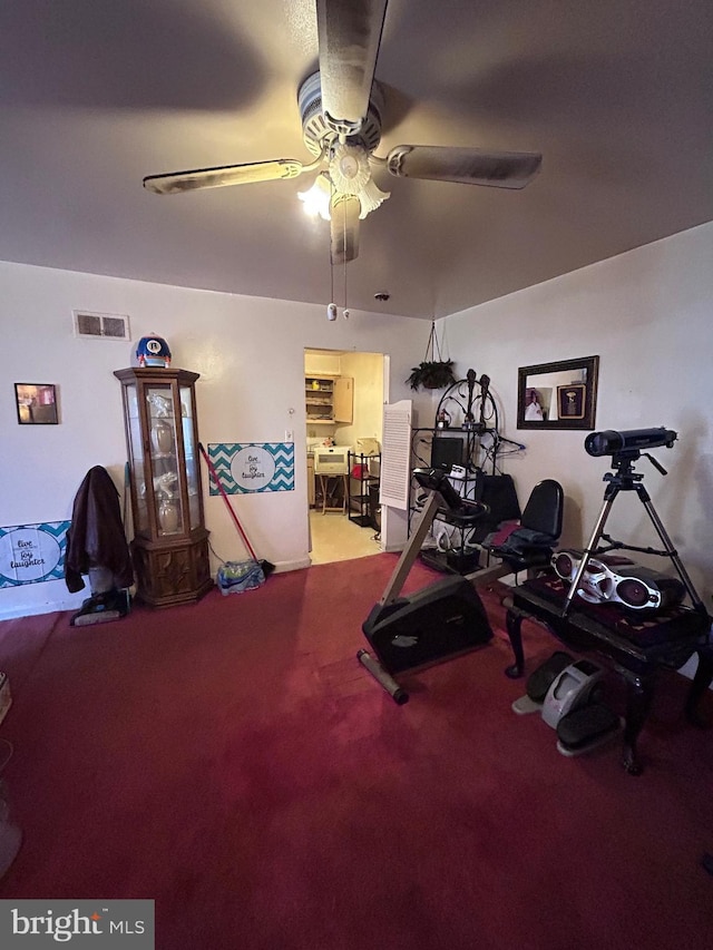 exercise area featuring carpet flooring, a ceiling fan, and visible vents