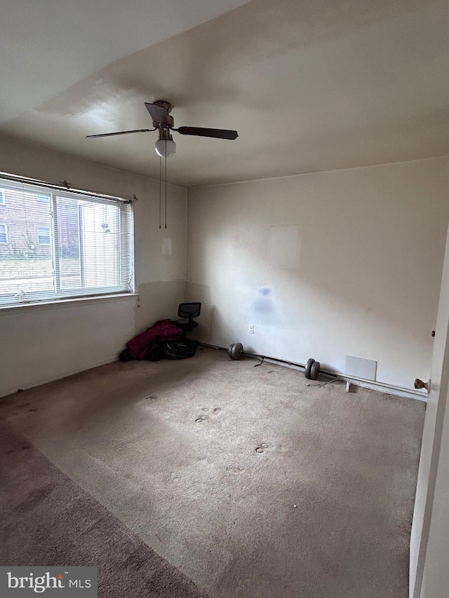 carpeted spare room with a ceiling fan