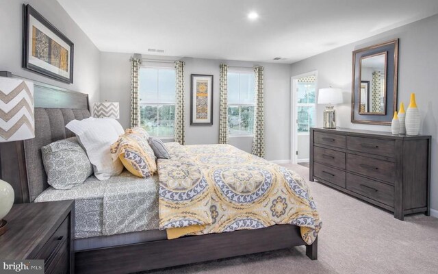 bedroom featuring visible vents, baseboards, and light colored carpet