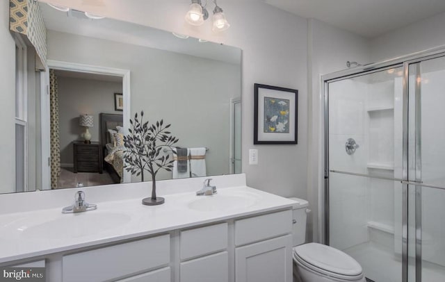 bathroom with double vanity, a stall shower, toilet, and a sink