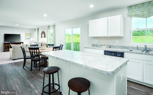 kitchen featuring black dishwasher, a center island, recessed lighting, and a sink