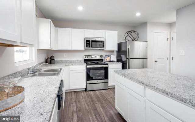 kitchen featuring a sink, dark wood-style floors, stainless steel appliances, white cabinets, and light countertops