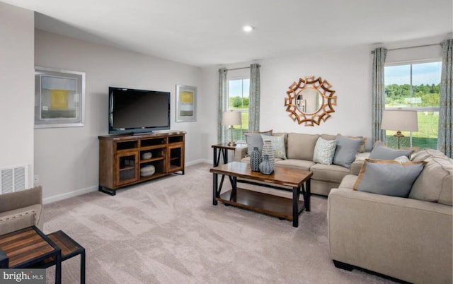 living area with a healthy amount of sunlight, visible vents, carpet floors, and baseboards
