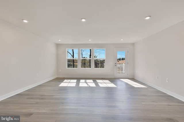 empty room featuring recessed lighting, baseboards, and wood finished floors