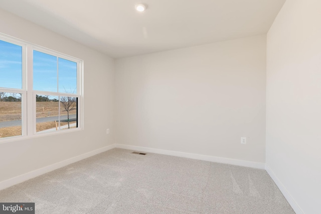 carpeted empty room featuring visible vents and baseboards