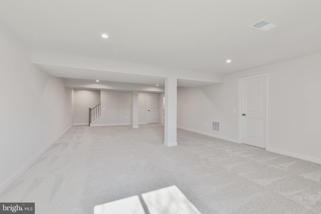 finished below grade area with recessed lighting, visible vents, baseboards, and light colored carpet