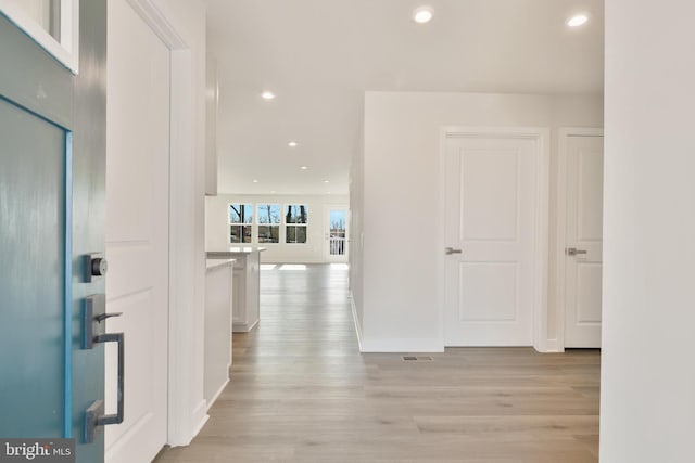 corridor with recessed lighting, light wood-type flooring, baseboards, and visible vents