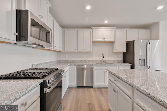 kitchen featuring a sink, white cabinetry, recessed lighting, light wood-style floors, and appliances with stainless steel finishes