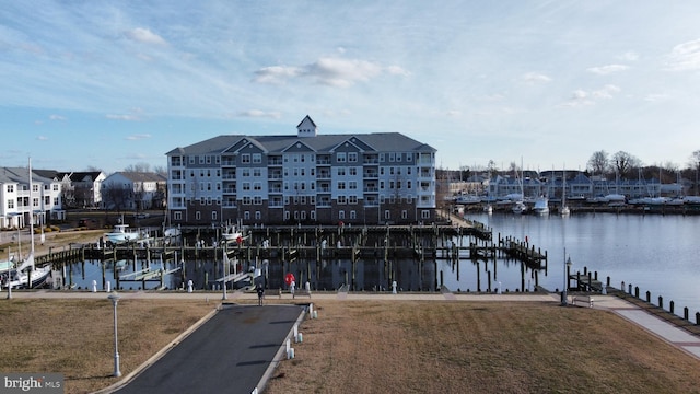 dock area with a lawn and a water view